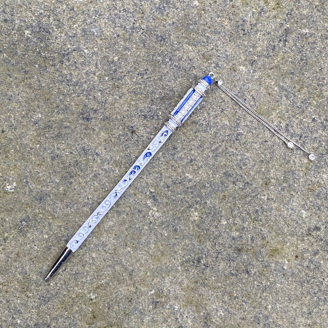 Elaborate LARP hairpin with blue accents and silver chain detail on stone.
