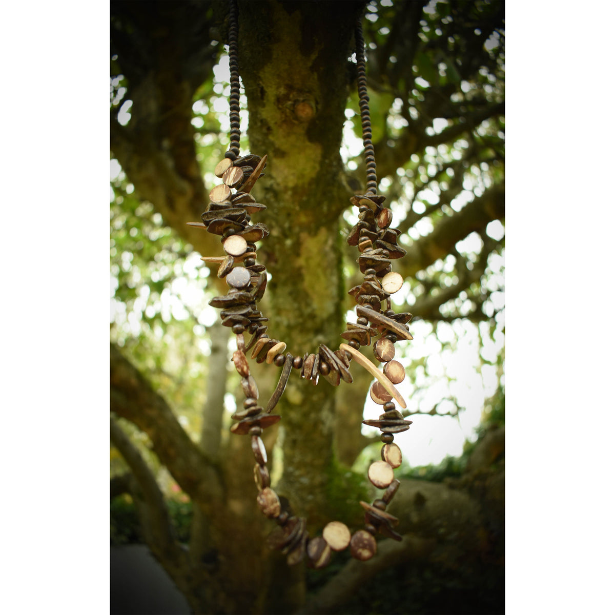 Orc tooth necklace hanging on tree branch for LARP.