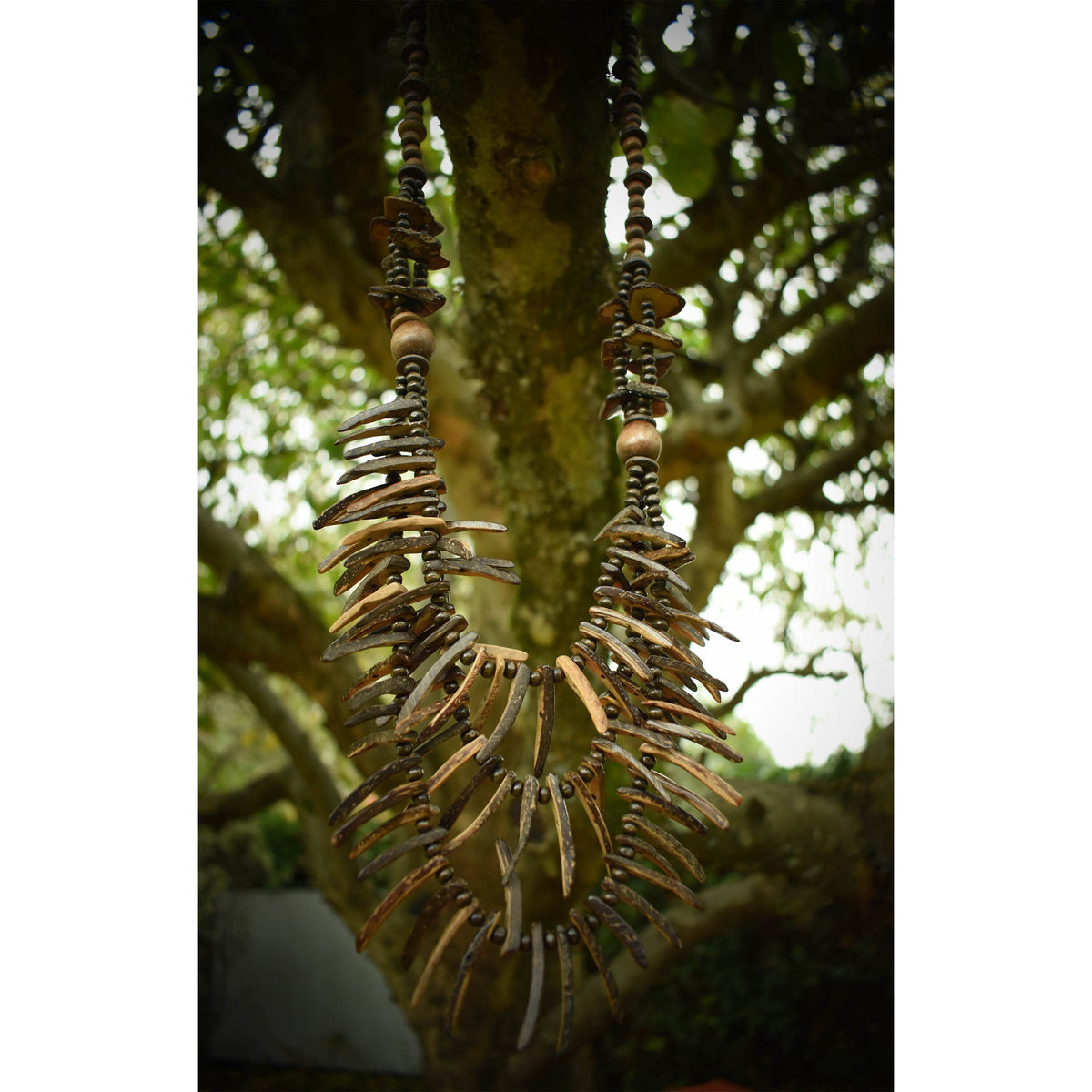 Rustic triple-layered tooth necklace in forest for LARP.
