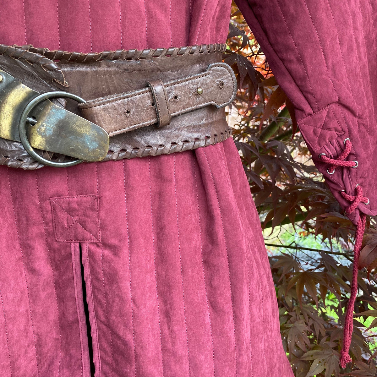 close up quilted padding detail on dark red gambeson.