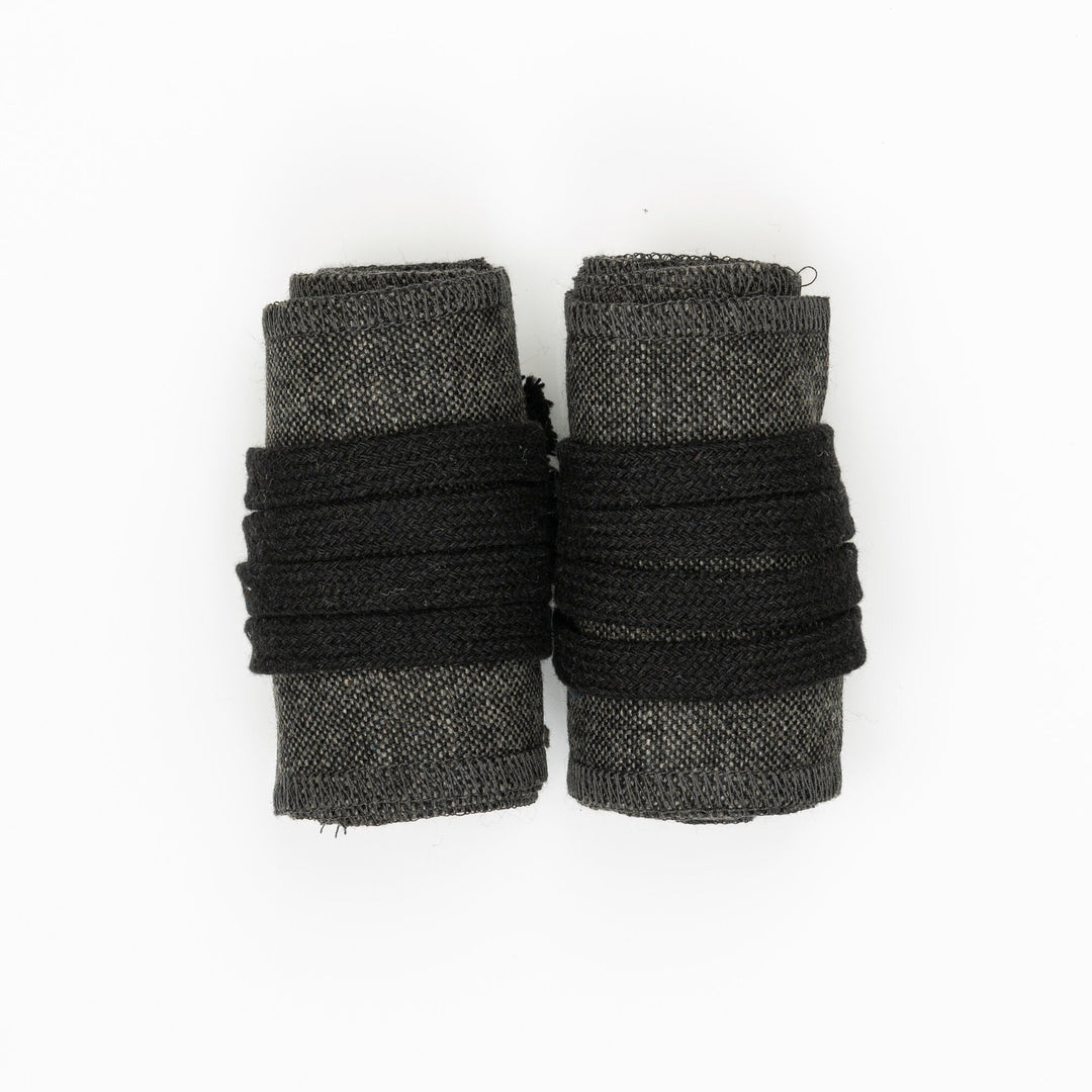 Light grey LARP wool arm wraps with black binding, top view.