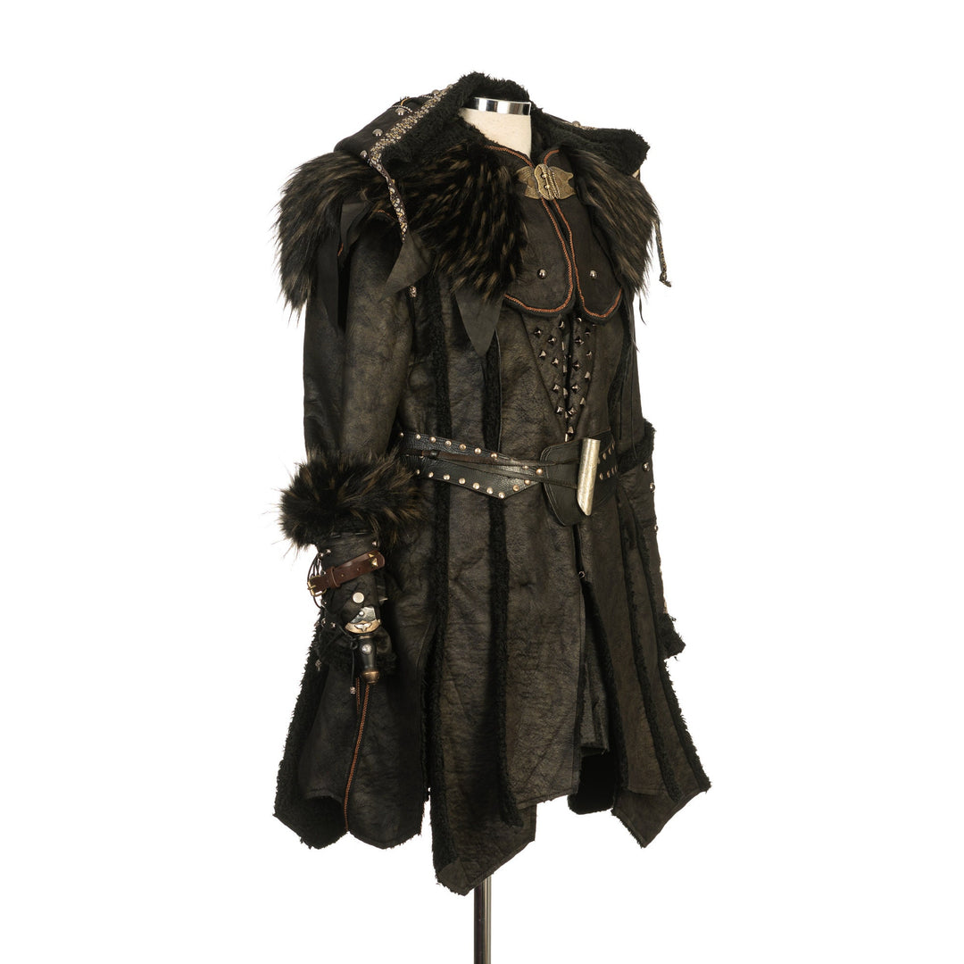 LARP medieval set side view; black outfit with fur details and vambraces.