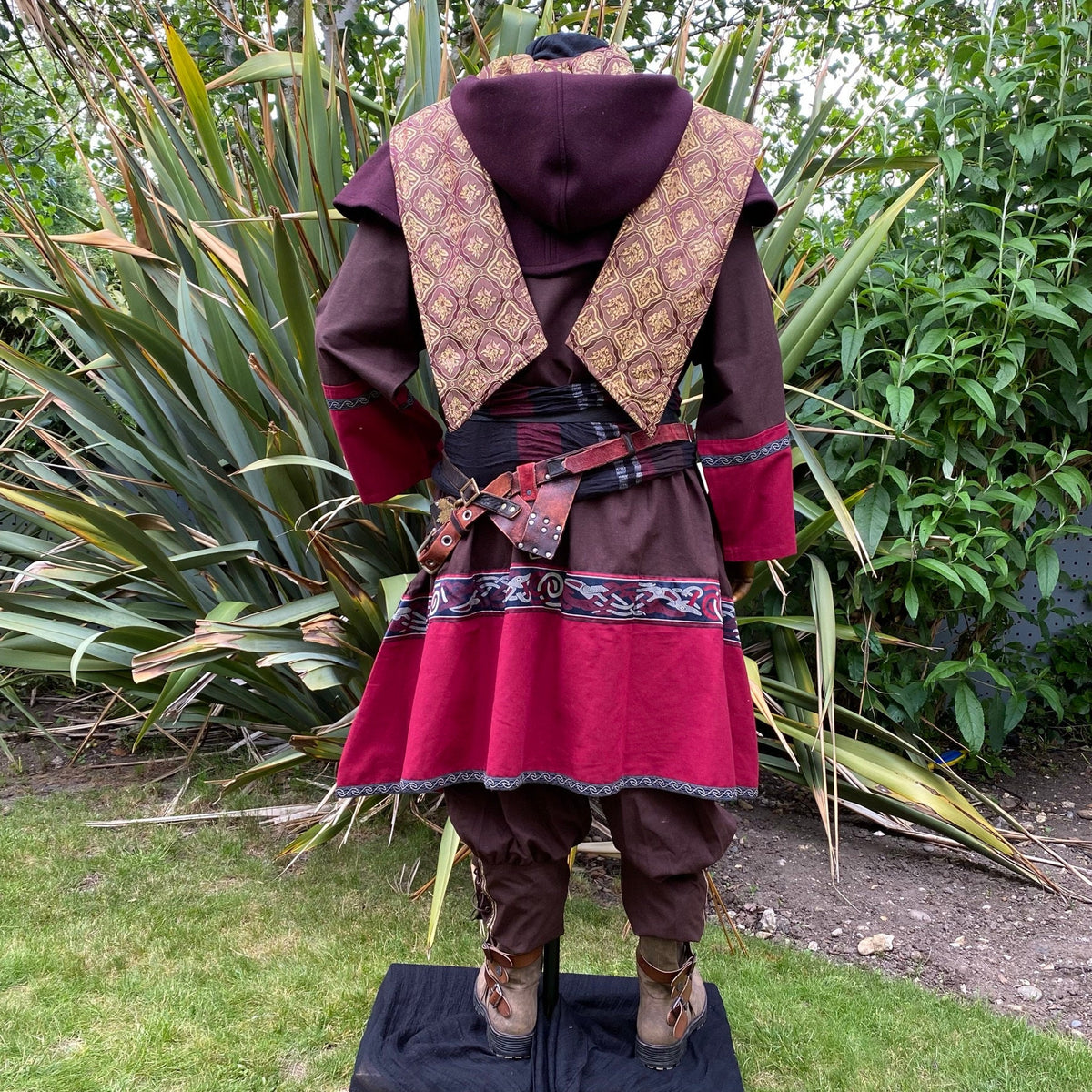 Back view of LARP bard outfit with patterned purple hood and belt accents.