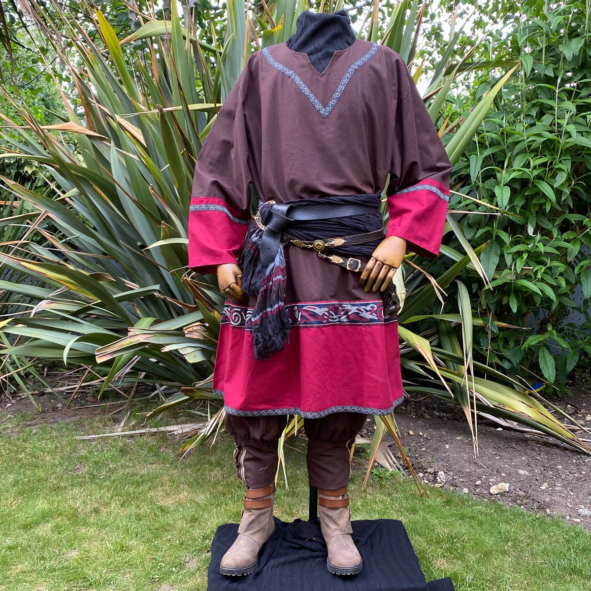 LARP medieval bard attire with red trim detail and layered sashes.