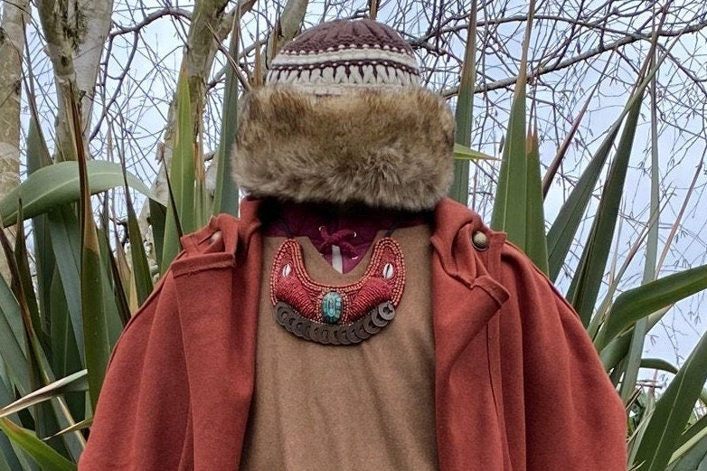 Winter LARP outfit with Maasai necklace on fur-collared coat.