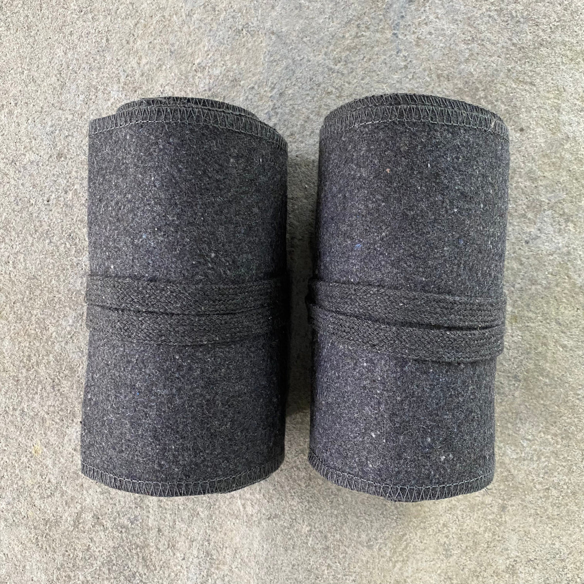 Dark grey wool leg wraps rolled, top view for LARP.