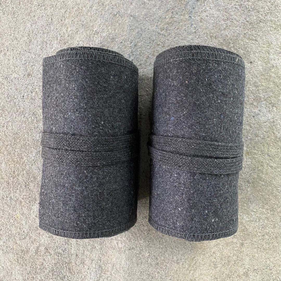 Dark grey wool leg wraps rolled, top view for LARP.