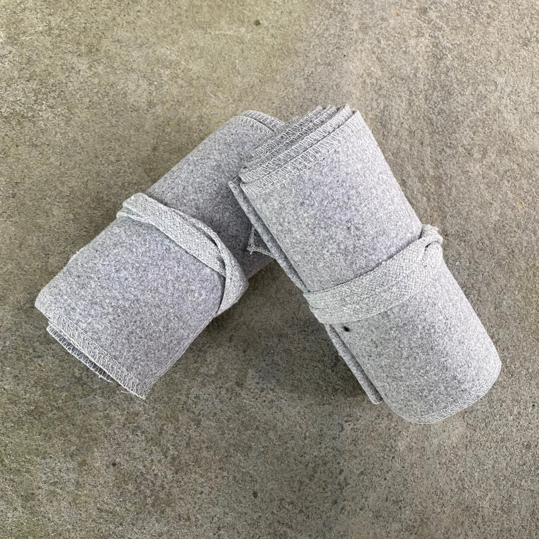 Top view of rolled light grey wool leg wraps for medieval LARP.