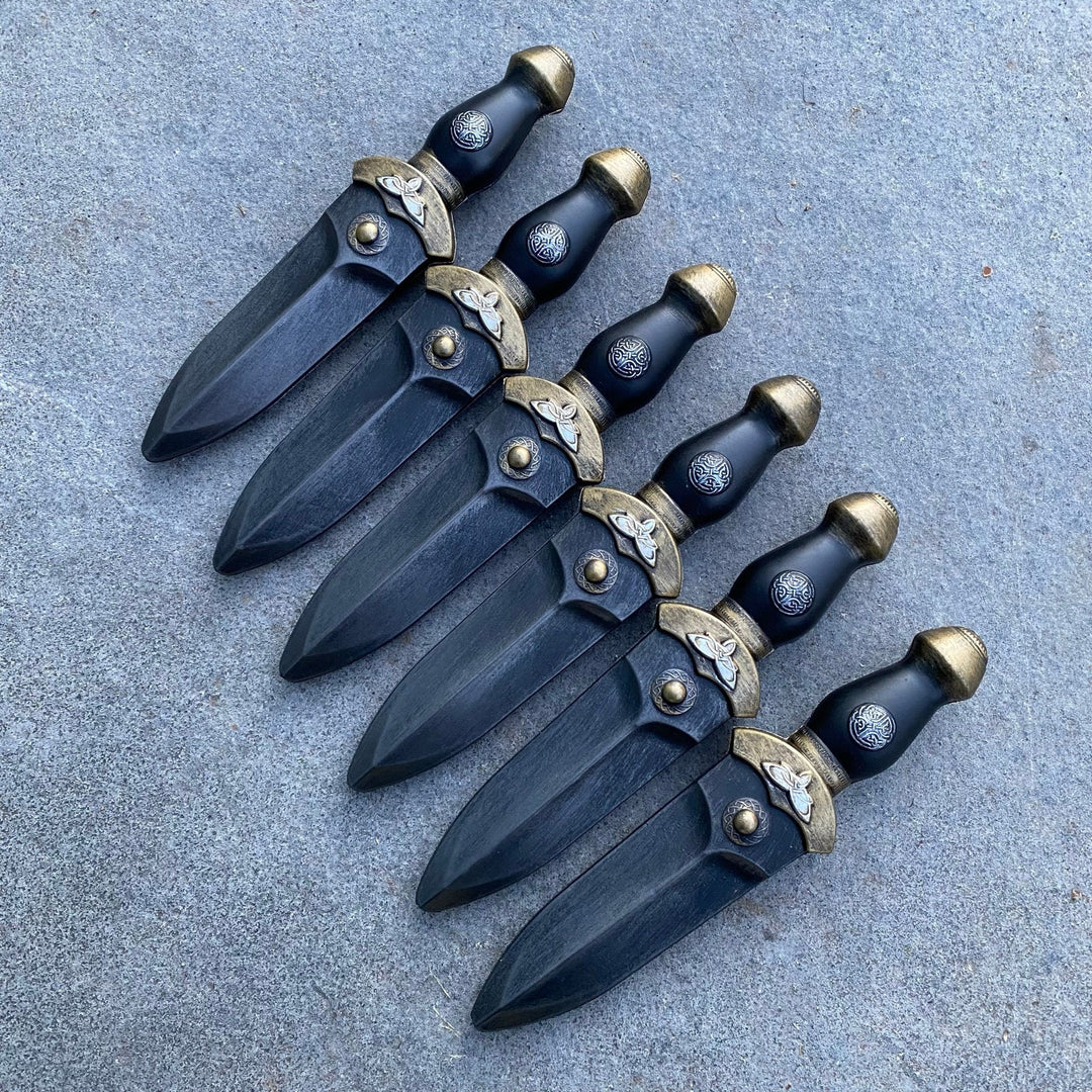Set of 6 LARP daggers laid flat, ornate hilt detail, medieval styling.