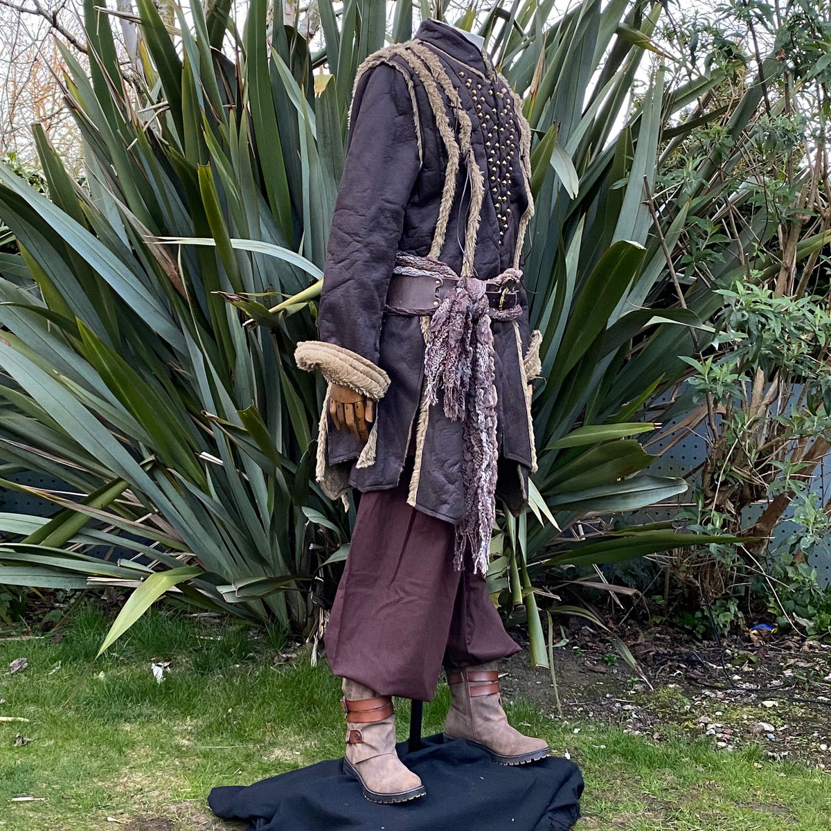 Three-quarter front angle of brown faux leather LARP coat showing V-shaped studded front.
