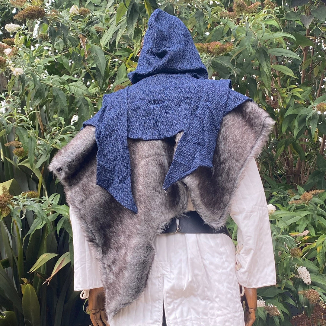 Rear view of blue hooded LARP faux fur mantle against lush greenery.