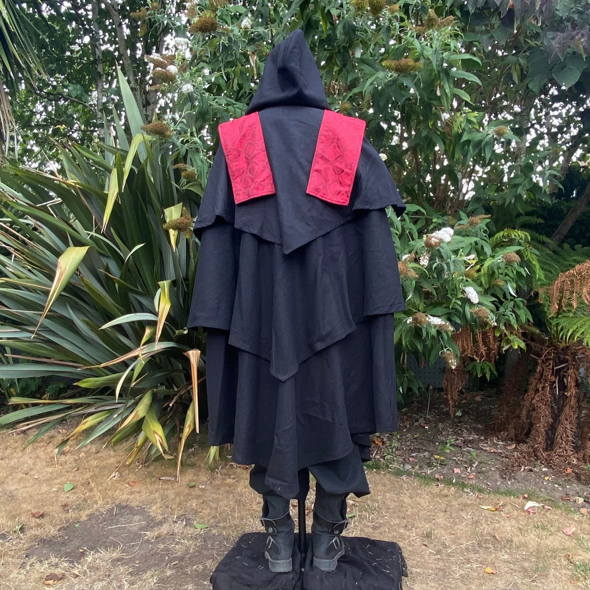 Medieval LARP costume back view featuring a 3-layered cloak, shirt and sash.