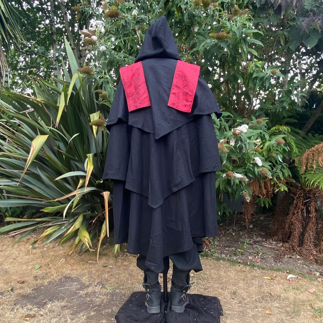 Medieval LARP costume back view featuring a 3-layered cloak, shirt and sash.
