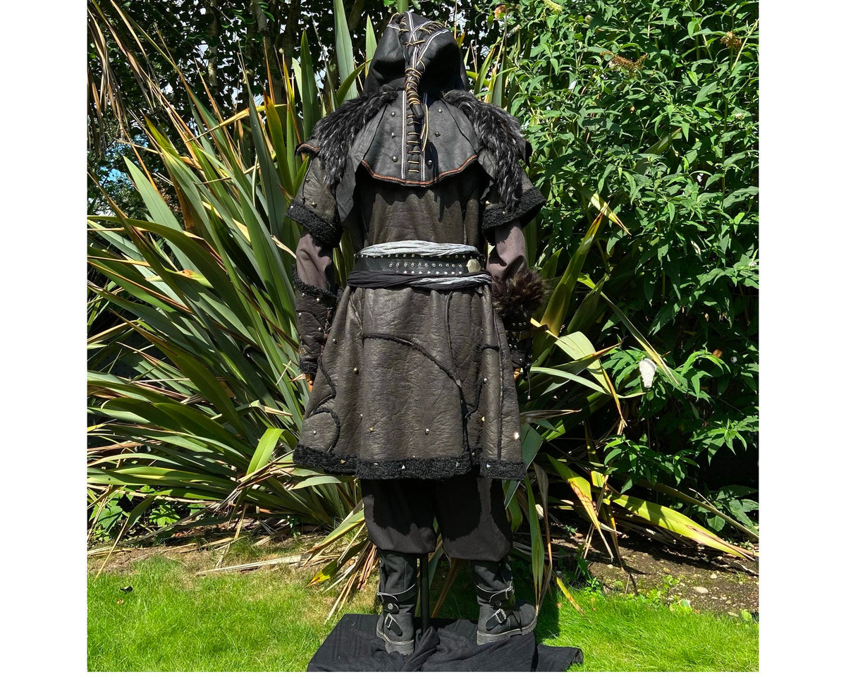 Medieval LARP costume back view featuring a black faux leather tunic, hood, vambraces, shirt.