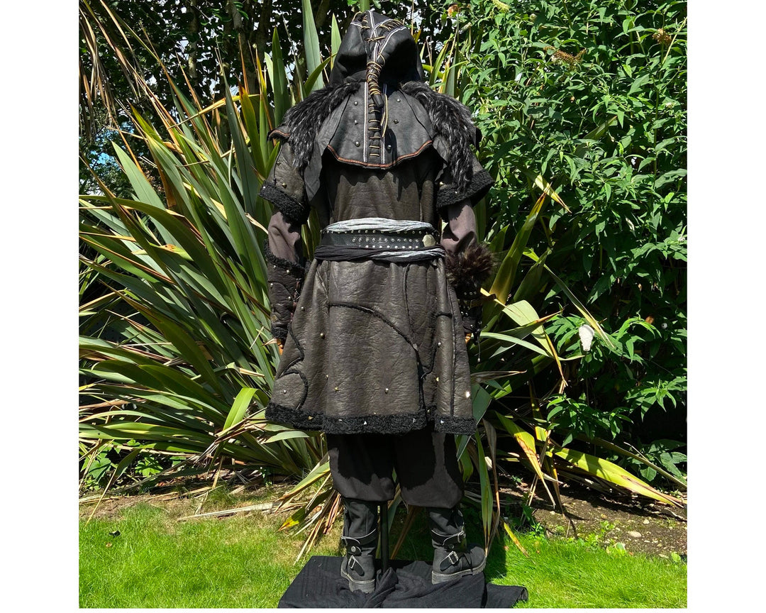Medieval LARP costume back view featuring a black faux leather tunic, hood, vambraces, shirt.