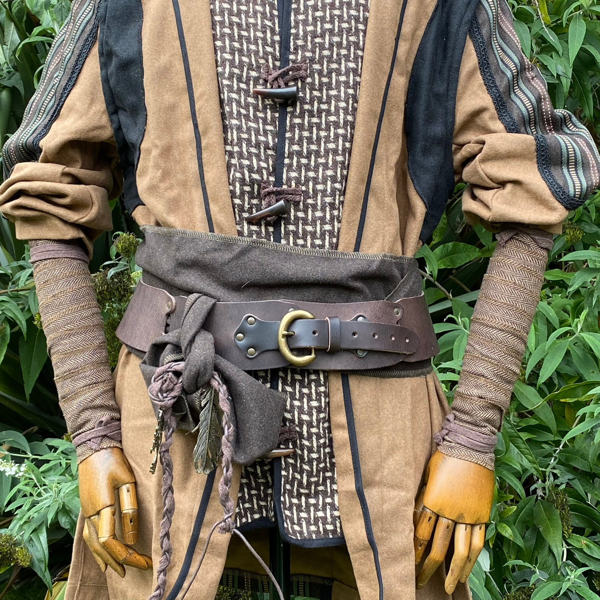 Medieval LARP costume with brown herringbone arm wraps and belt detail.
