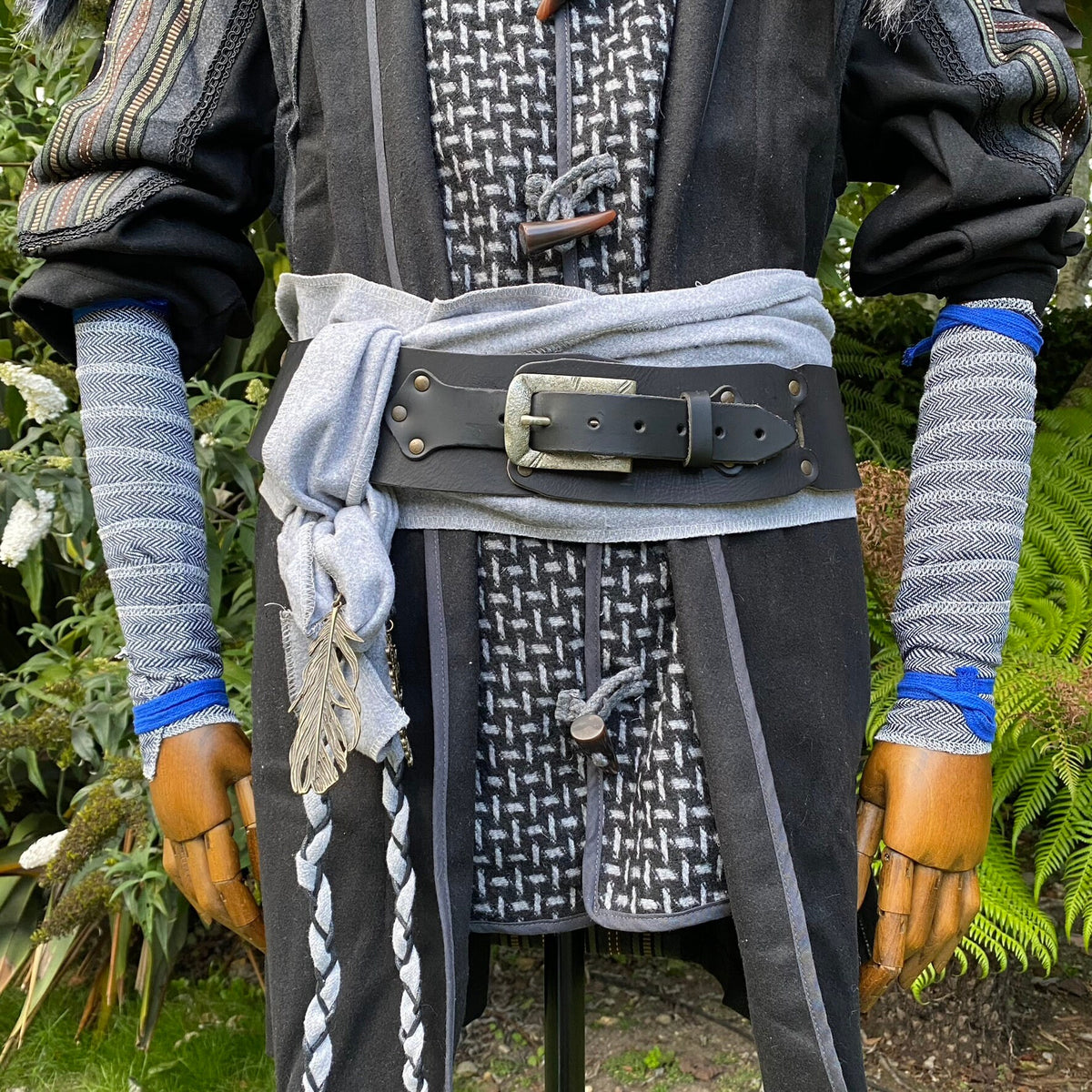 LARP medieval costume with blue herringbone arm wraps and belt detail.