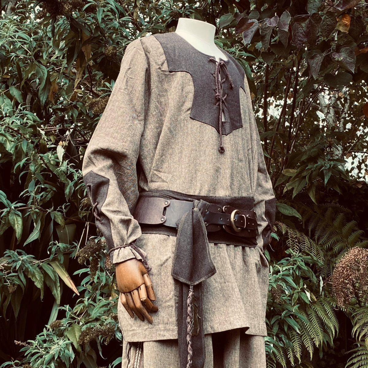 Two-tone wool Viking shirt with leather belt in a lush medieval.