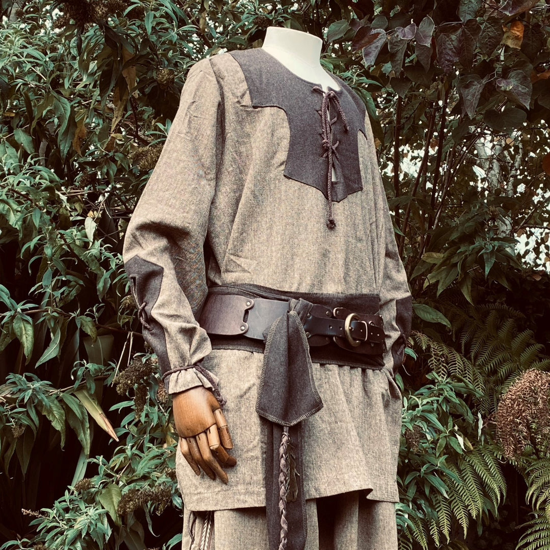 Two-tone wool Viking shirt with leather belt in a lush medieval.