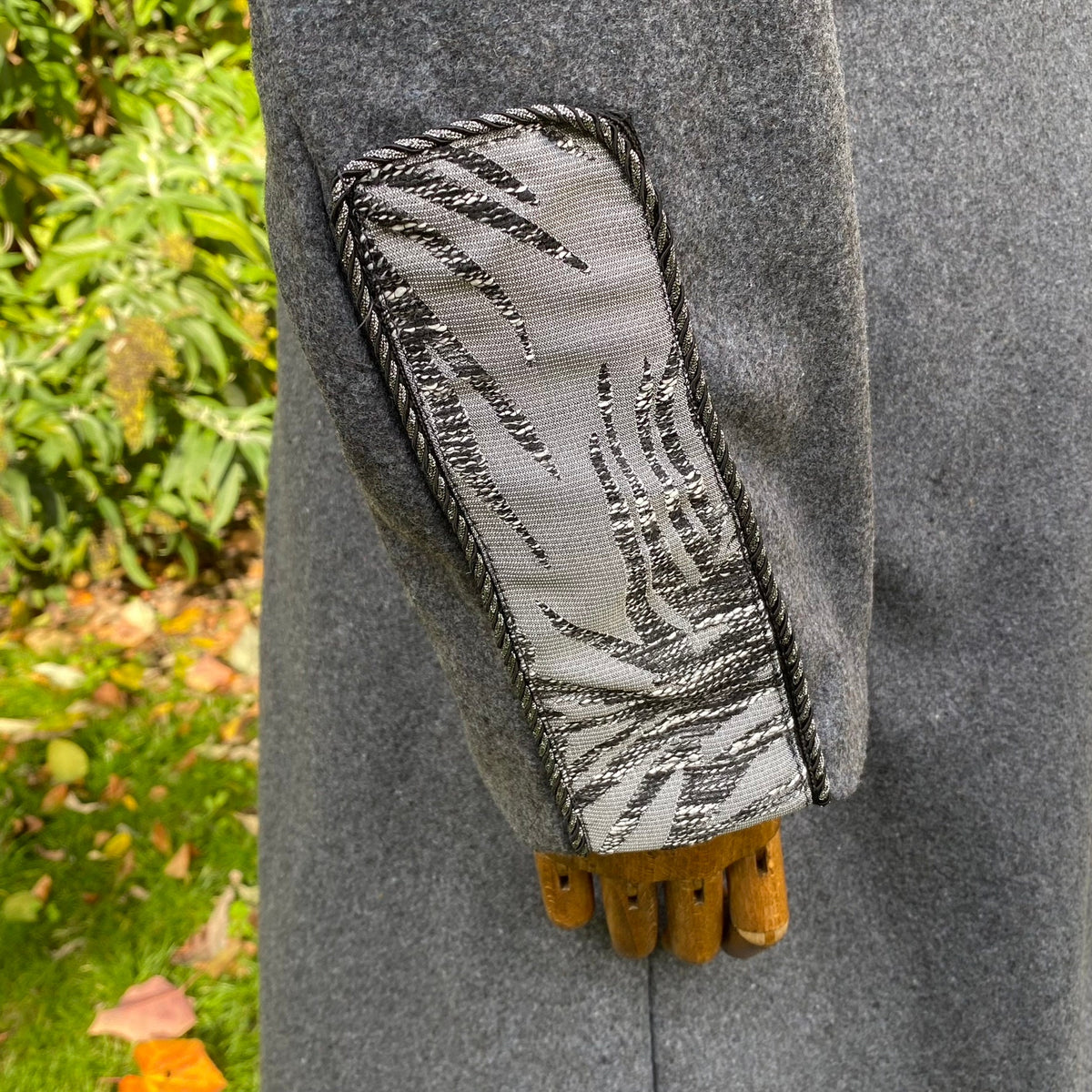 Grey LARP coat sleeve with intricate silver embroidery detail.