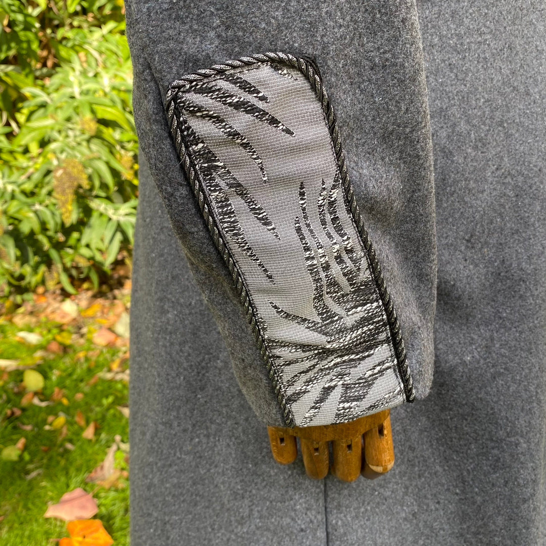 Grey LARP coat sleeve with intricate silver embroidery detail.