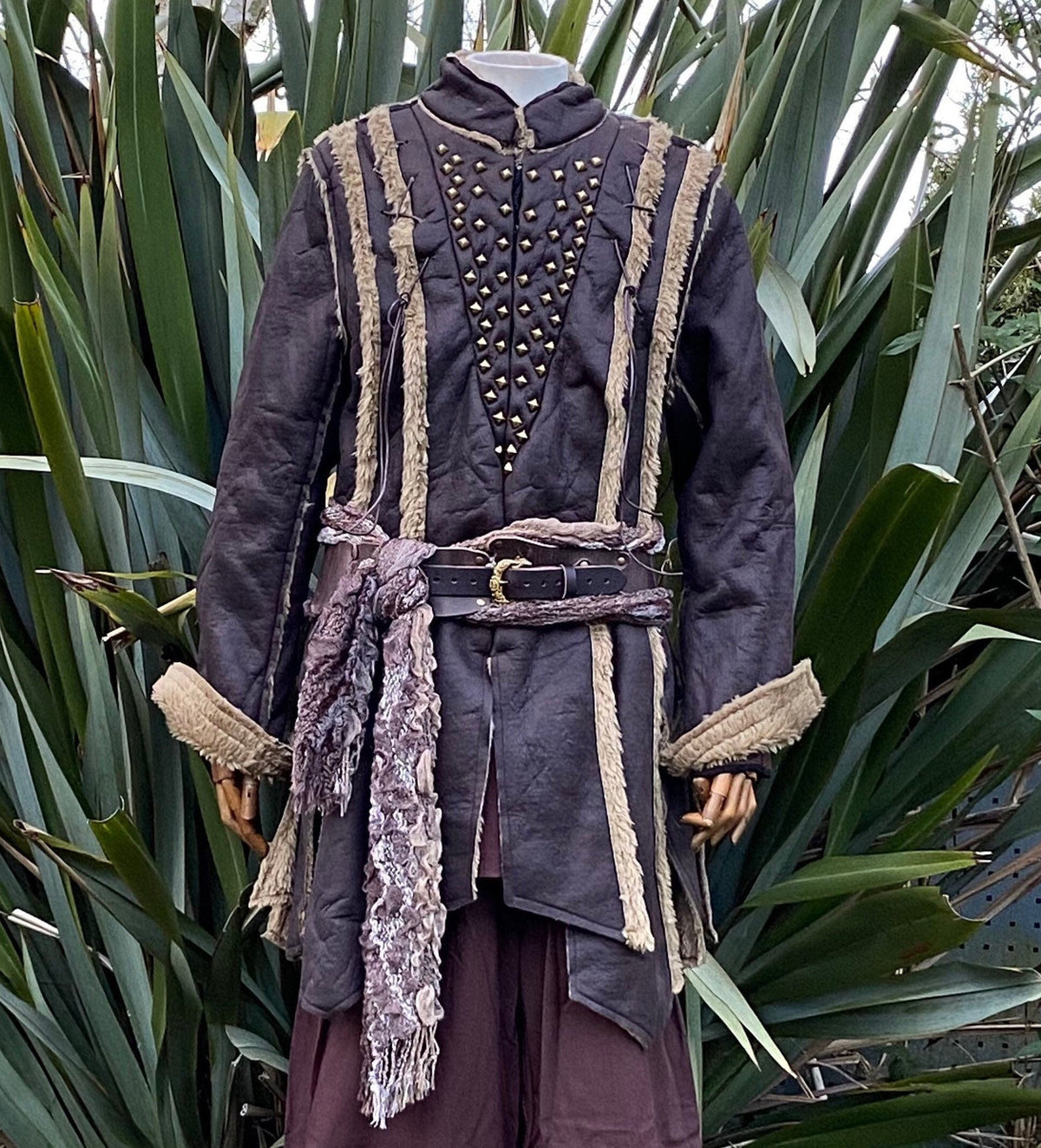Front view of faux leather Viking coat with metal studs and textured belt.