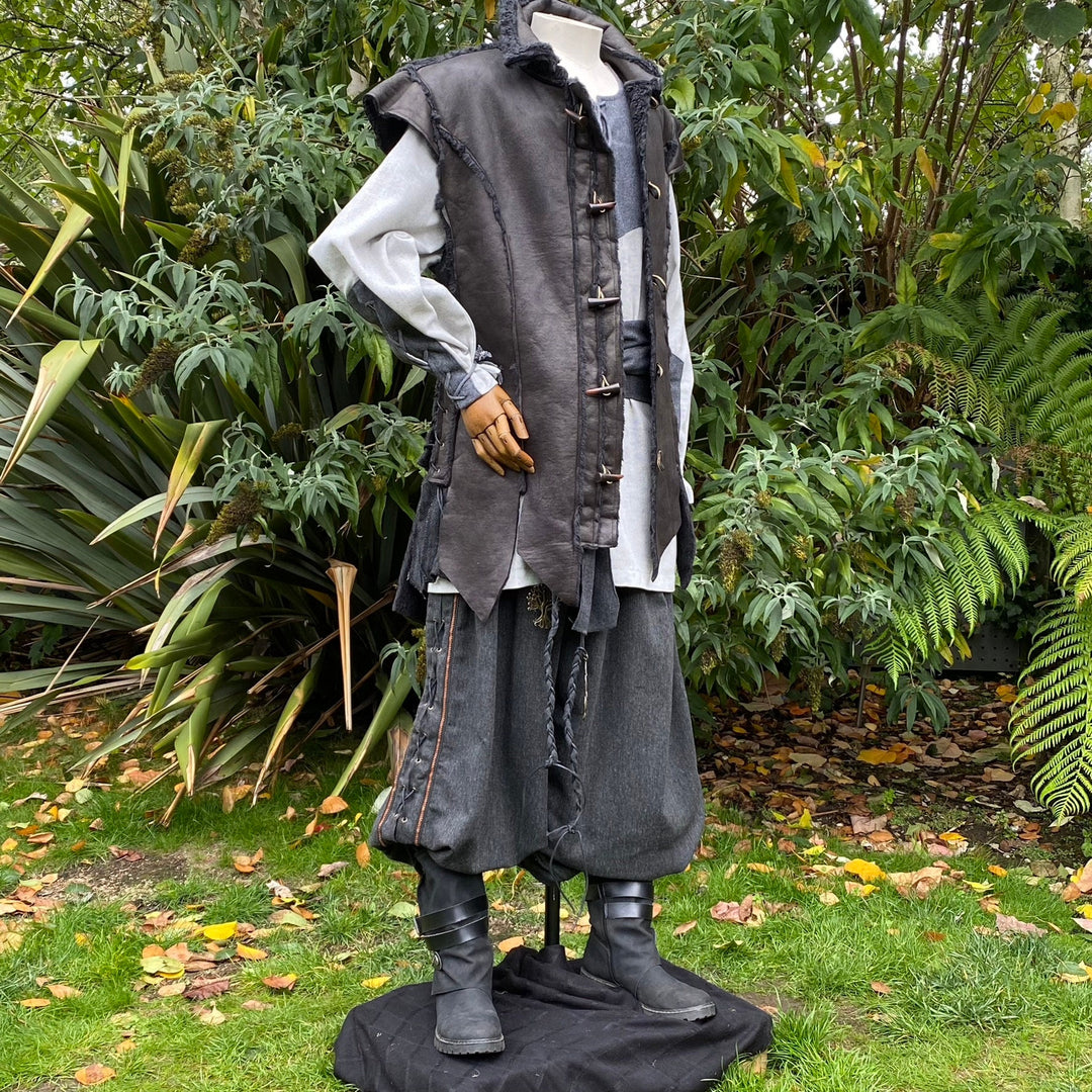 Three-quarter view of black medieval waistcoat showing horn toggle fastenings and layered textures.