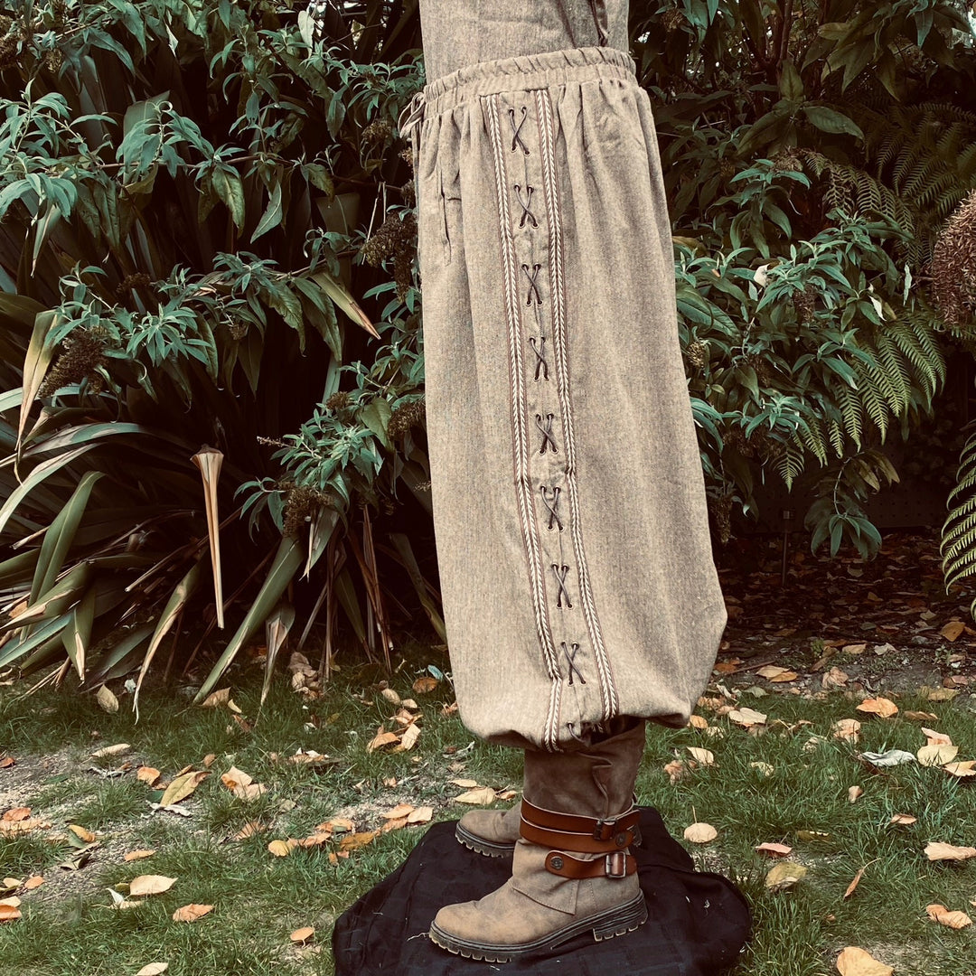 Side view of laced brown wool medieval LARP trousers with tall boots.