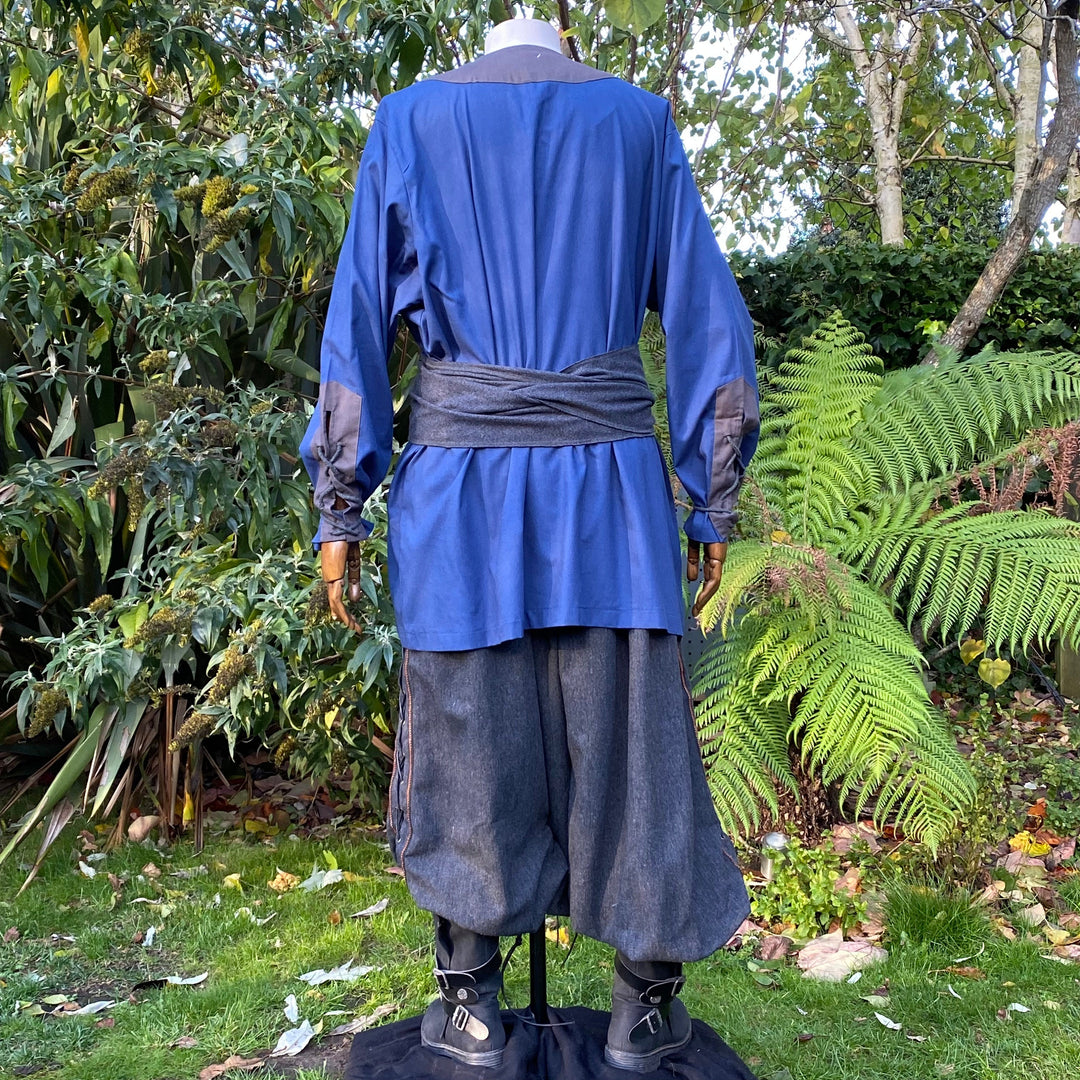 Back view of blue medieval tunic with grey sash in garden setting for LARP.