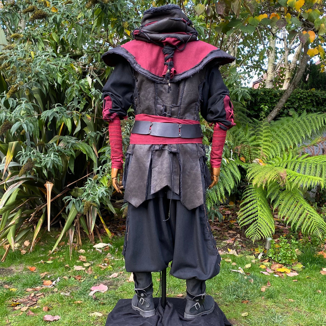 Medieval LARP outfit back view, featuring a red and black hood, waistcoat, shirt, and sash.