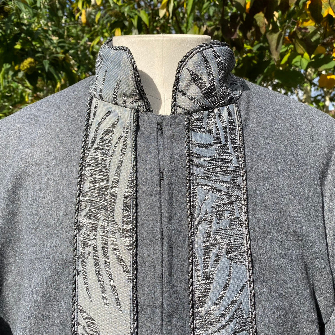 Grey LARP coat close-up with patterned high collar and trim, medieval style.