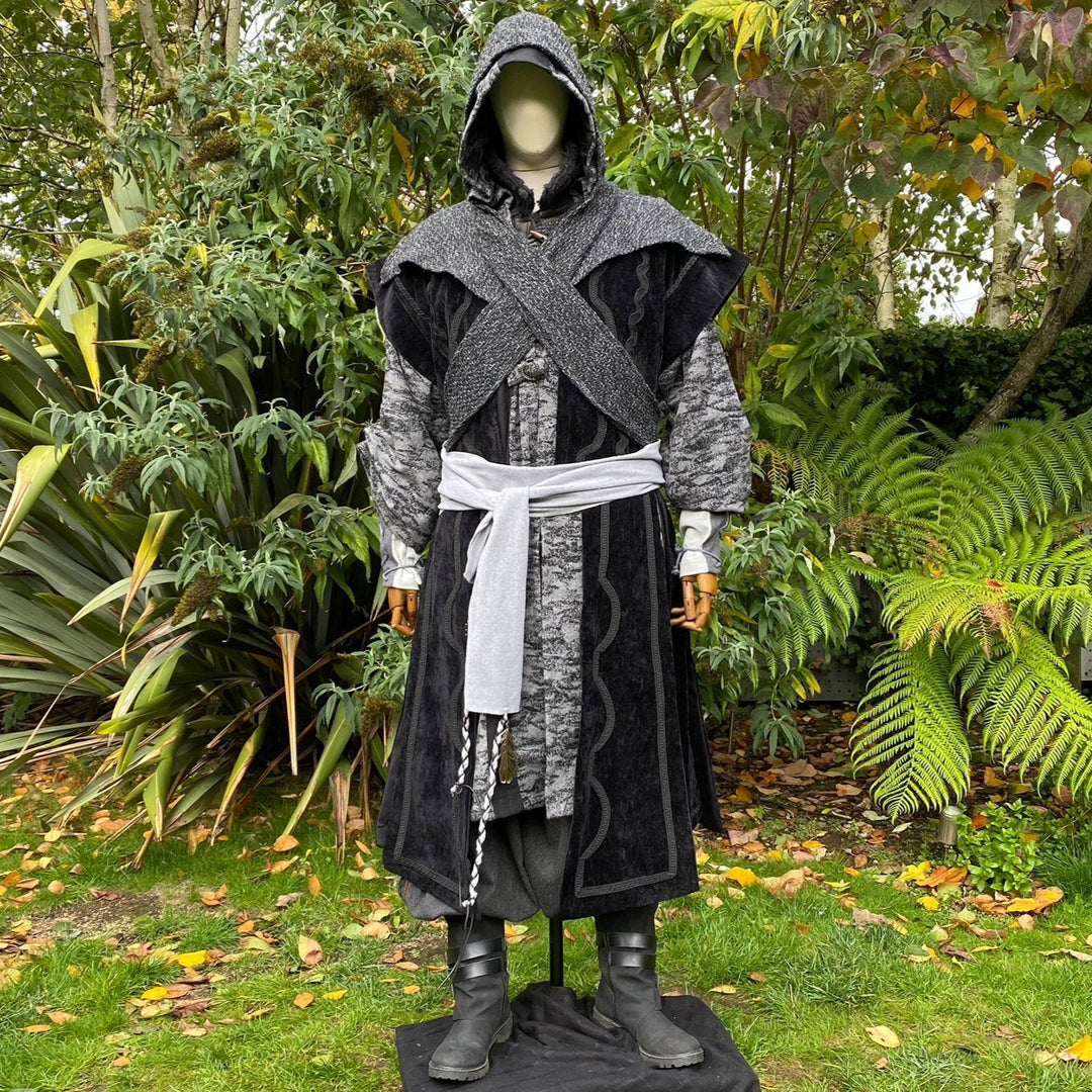 LARP costume in garden, grey hooded robe with white sash and dark boots.