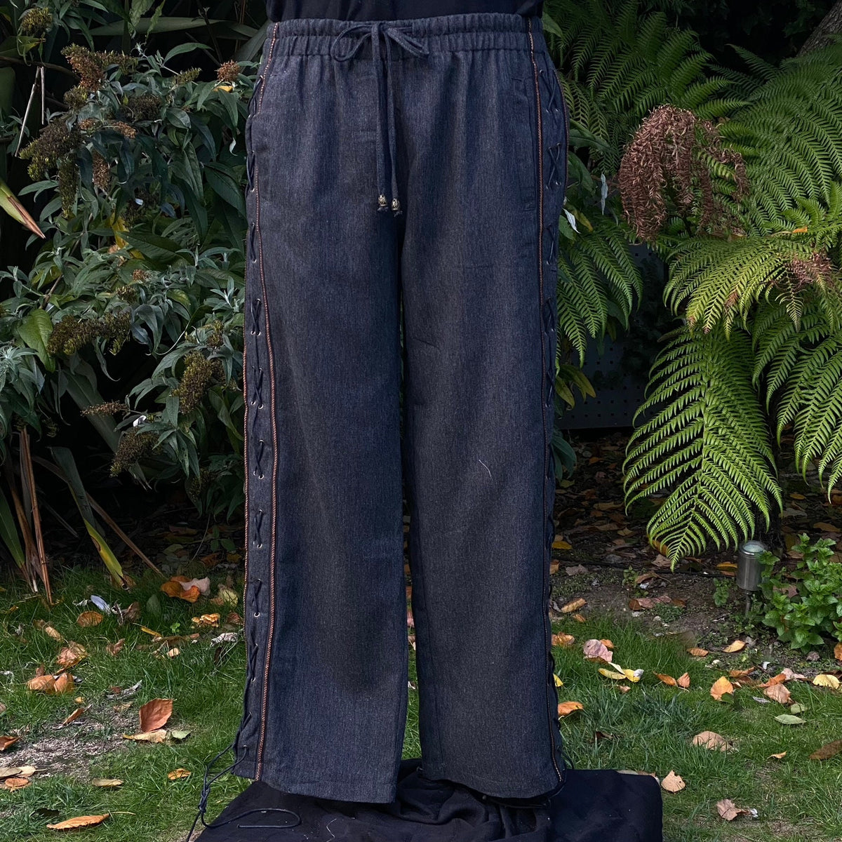 Front garden view of LARP medieval grey pants with braided side lacing.