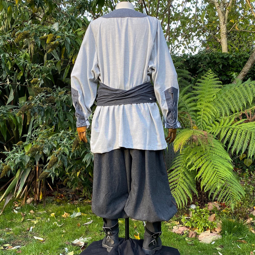 Back view of medieval LARP tunic with dark trim and billowy sleeves.