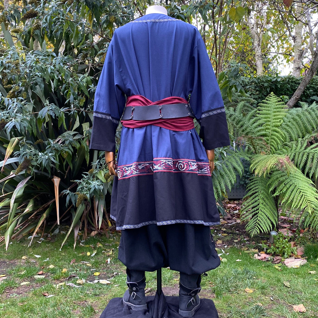Medieval LARP outfit back view, featuring a blue and black Viking tunic, trousers and sash.