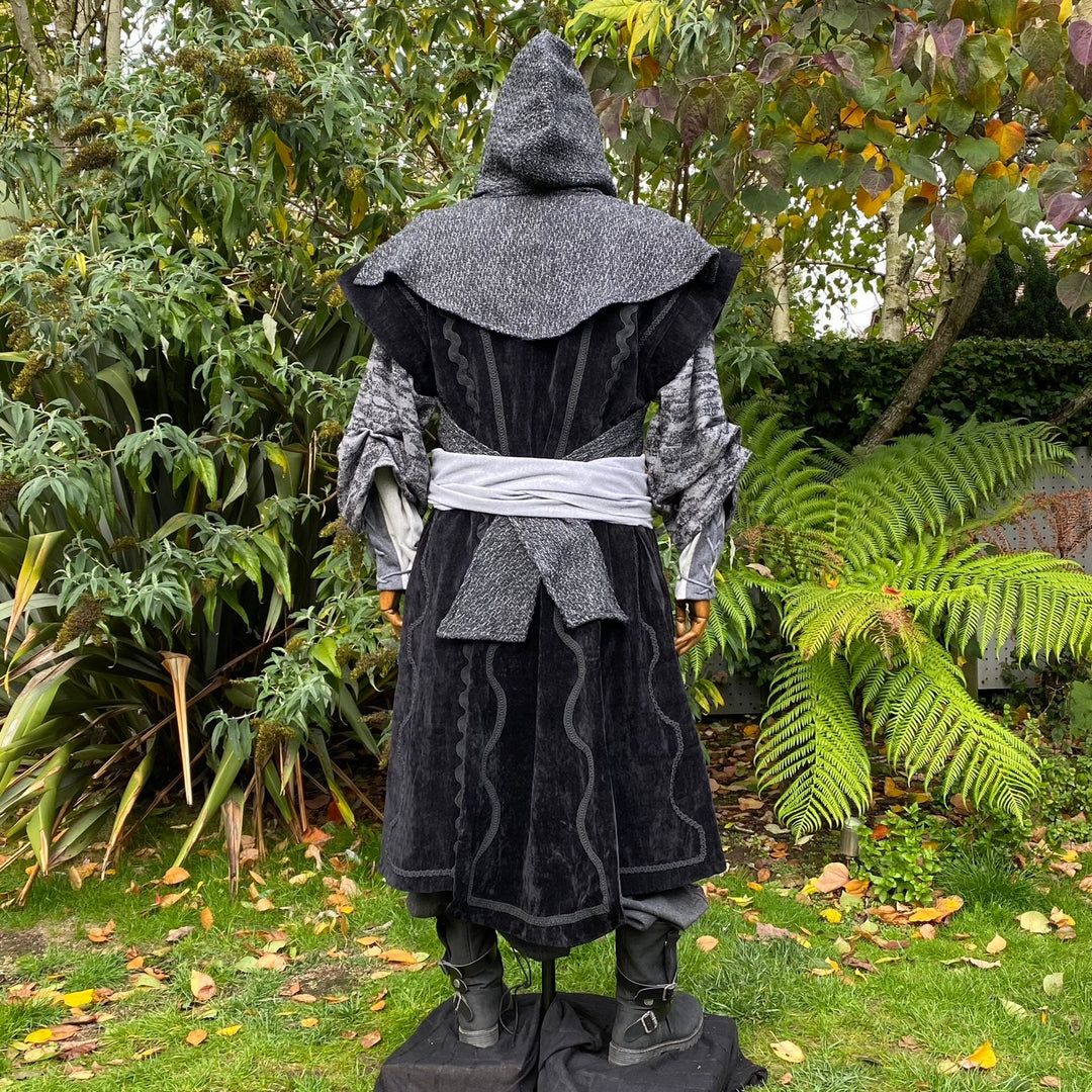 Rear view dark medieval LARP set; hooded robe with grey sash.