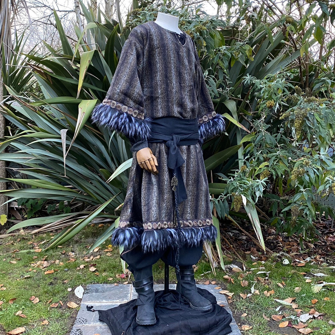 Viking LARP tunic in garden, fur cuffs, purple trim, side profile view.