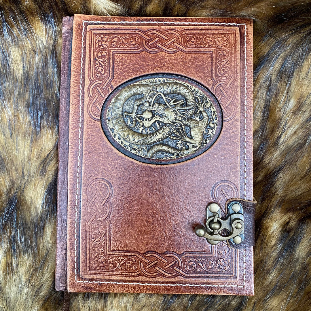 Brown leather A5 medieval LARP journal with embossed dragon design, top view.