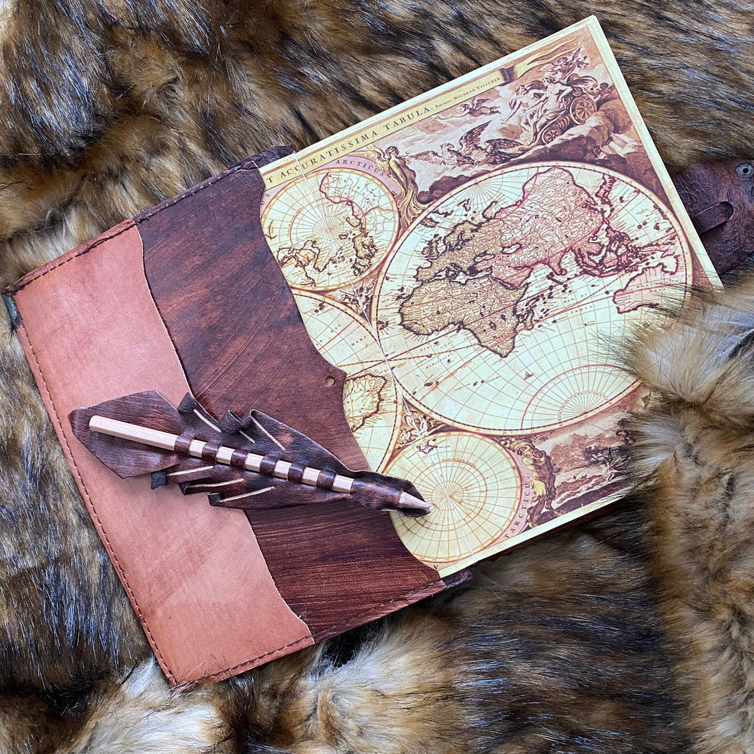 Medieval leather journal with map design, quill pocket on fur backdrop.