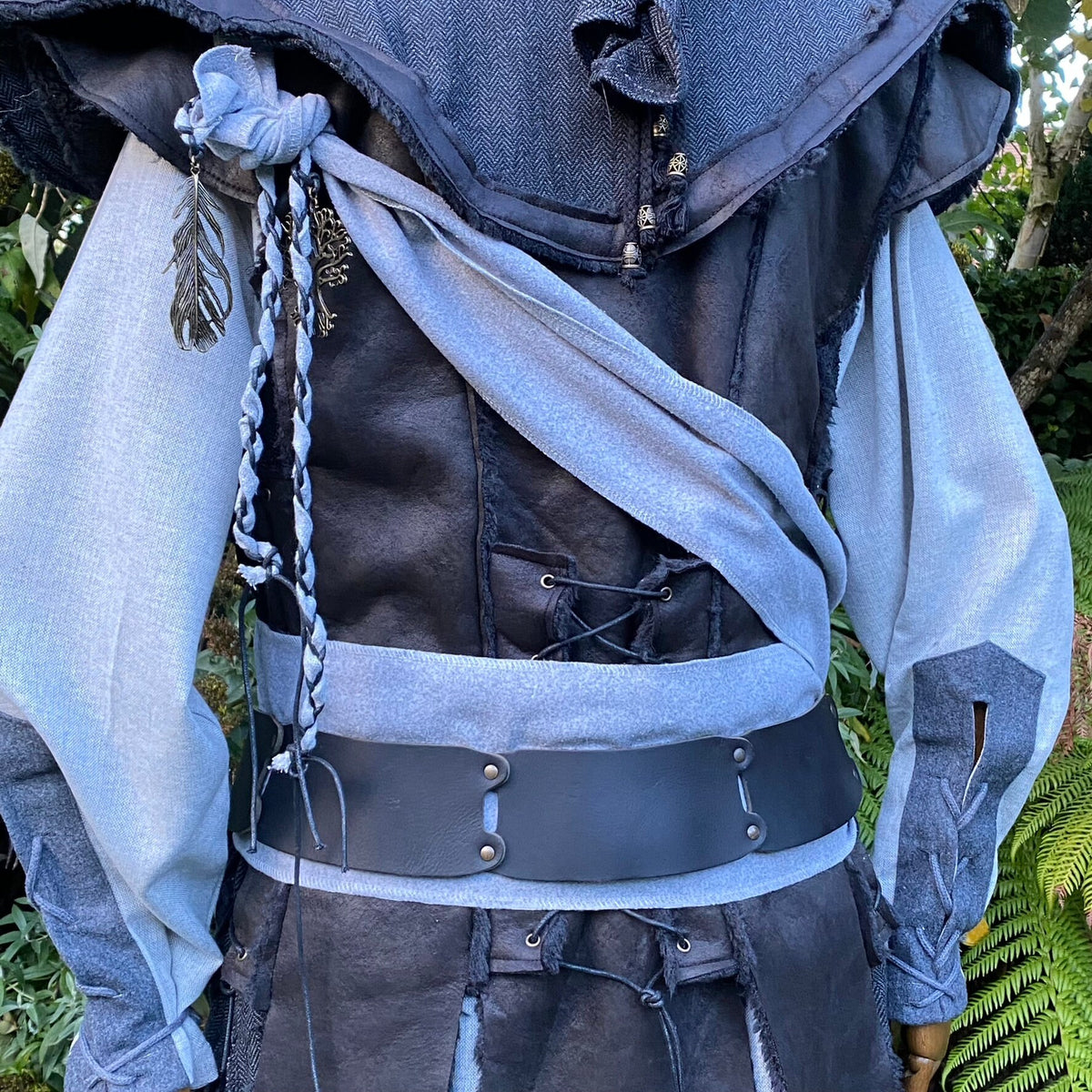 LARP costume with twisted grey sash and braided detail, forest backdrop.