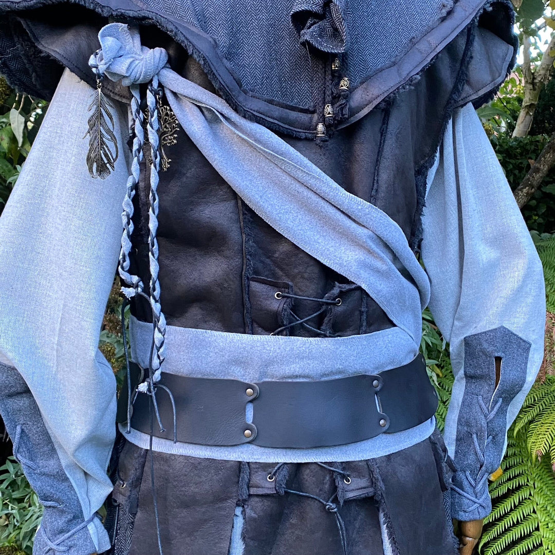 LARP costume with twisted grey sash and braided detail, forest backdrop.