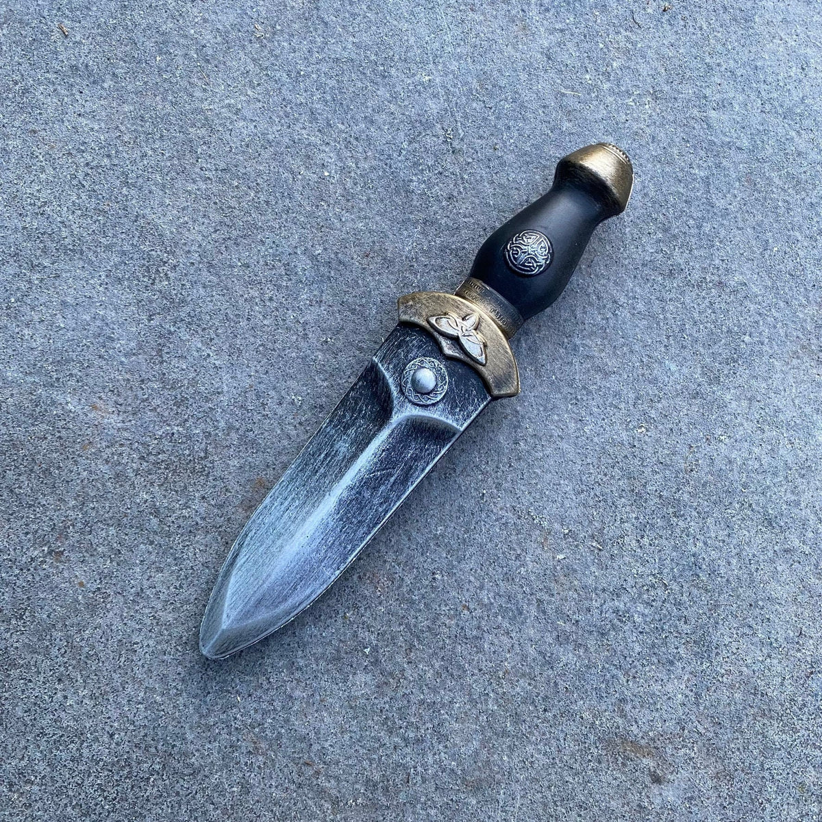 Medieval LARP foam dagger with engraved hilt, pewter finish on stone.