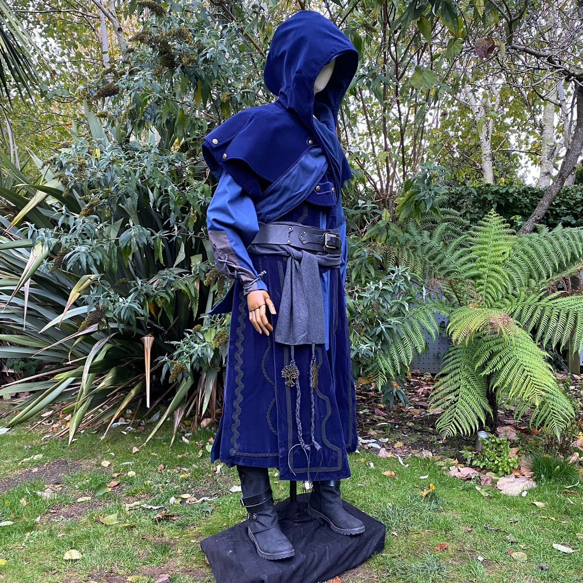 Mannequin in blue medieval LARP coat with belt and grey sash.