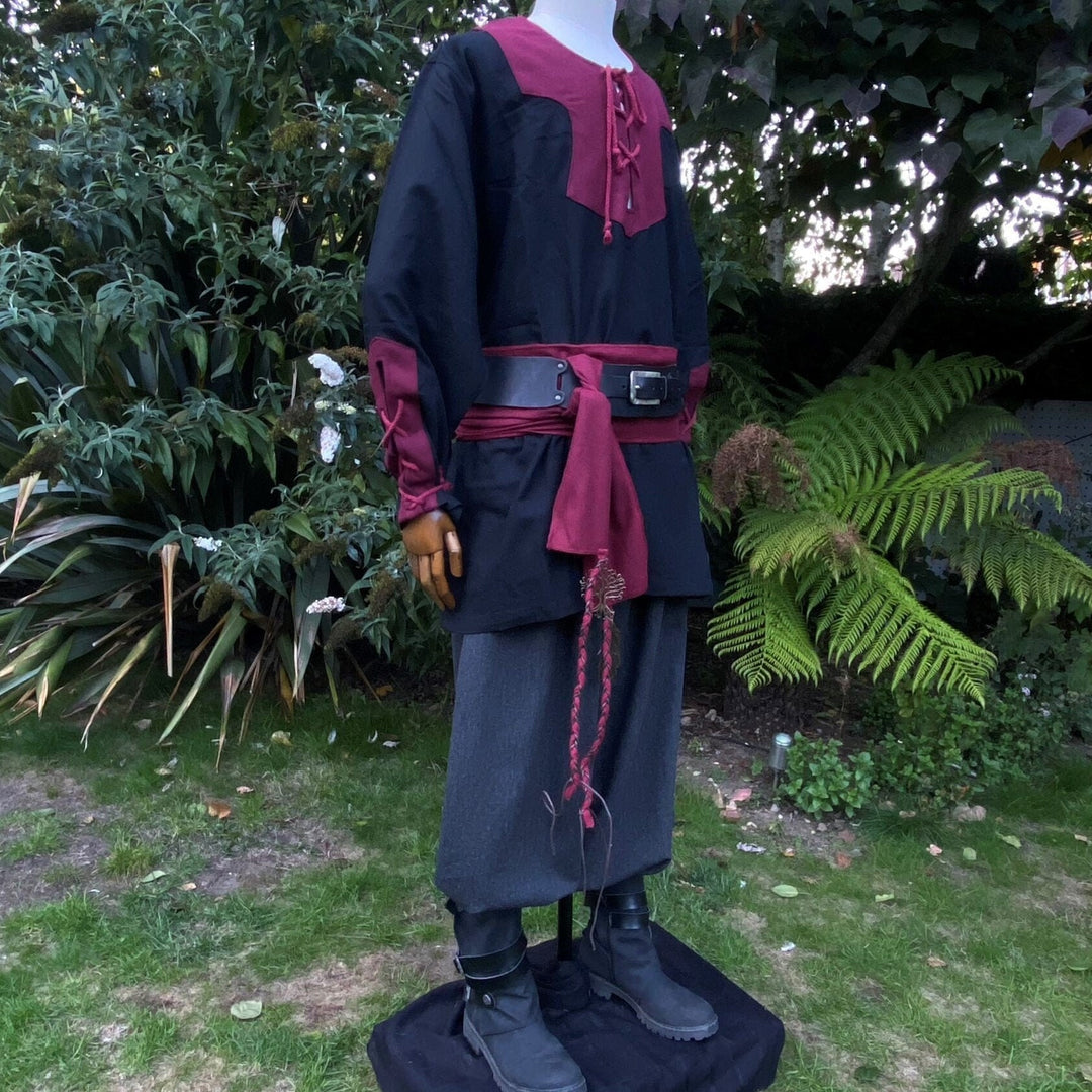 Medieval LARP outfit side view, featuring a black and red viking tunic, trousers and sash.