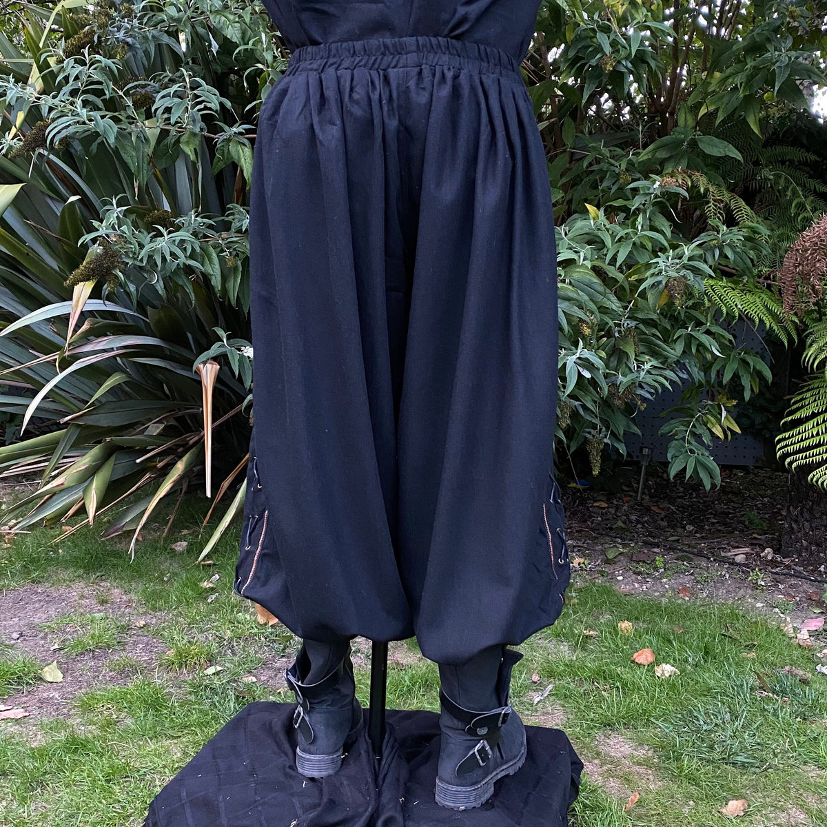 Black LARP trousers with side lace, braiding, and tucked boots.