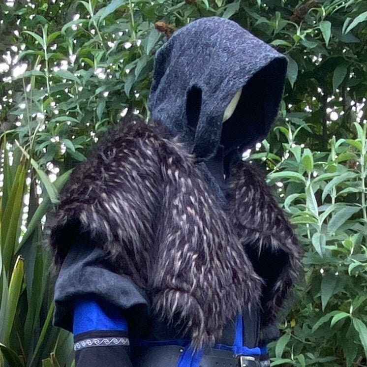 Medieval LARP outfit side view, featuring a grey wrap-around hood, and black and brown faux-fur.