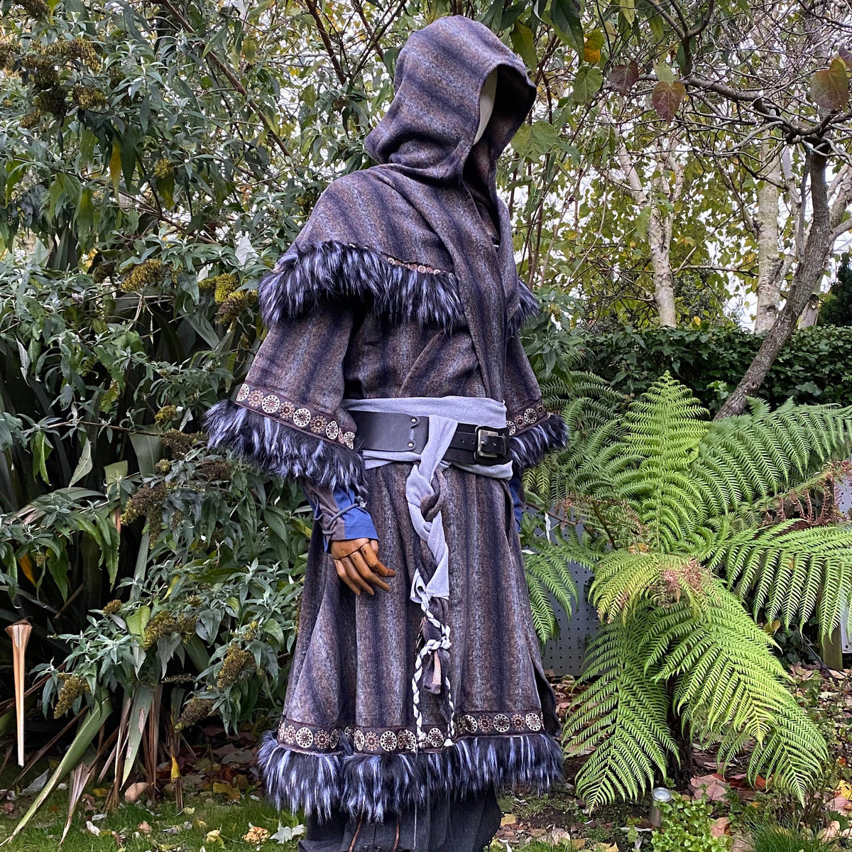 Medieval LARP outfit side view, featuring a blue and grey fur trim tunic, matching hood, and sash.