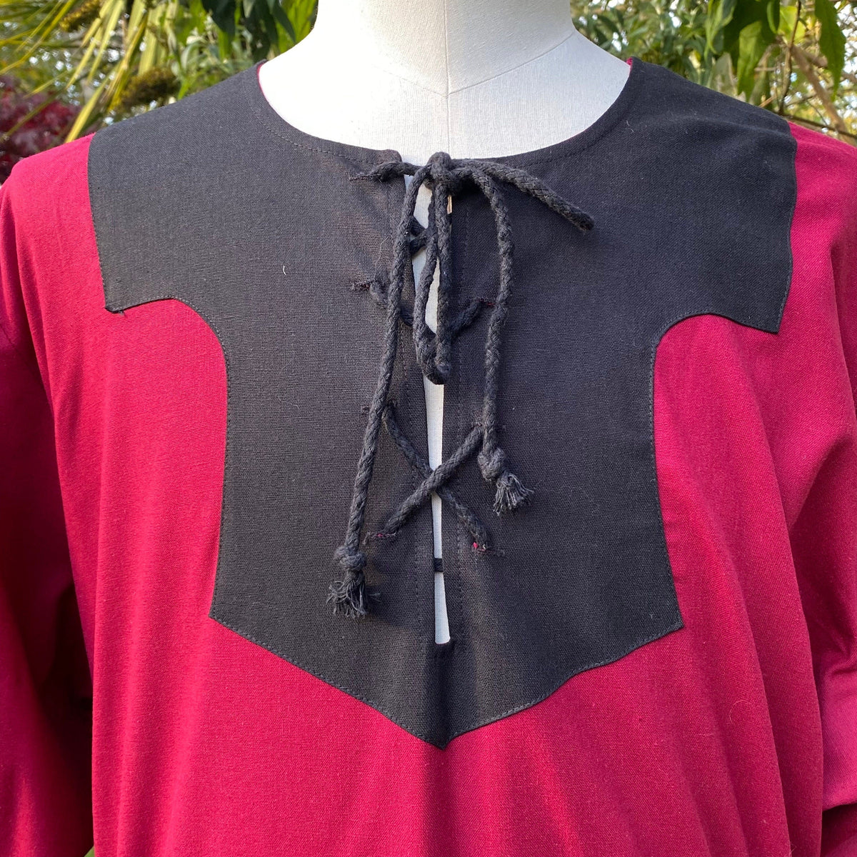 Close-up of LARP red and black shirt with lace-up detail on mannequin.