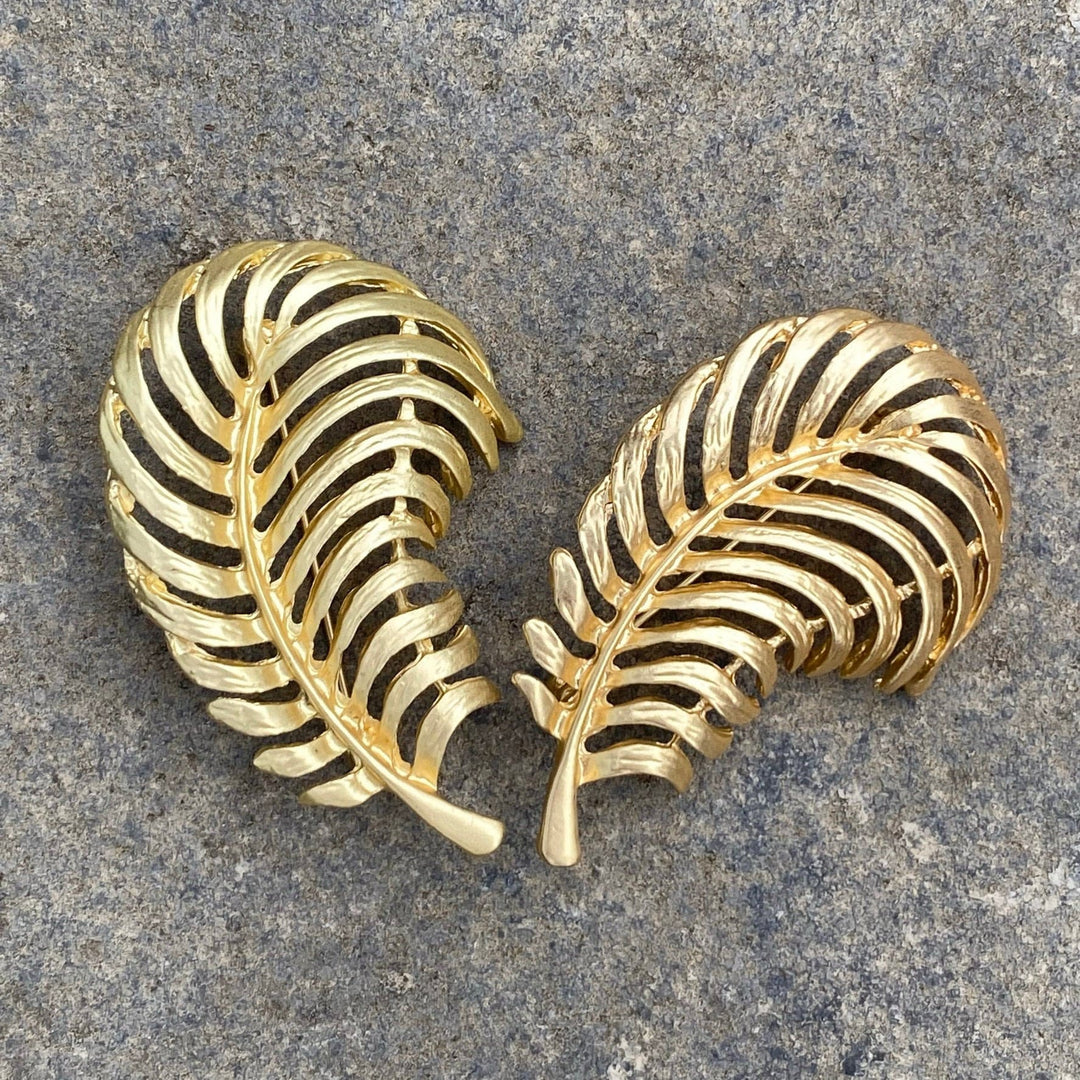 Gold fern brooches in a V-shaped overlay for LARP.