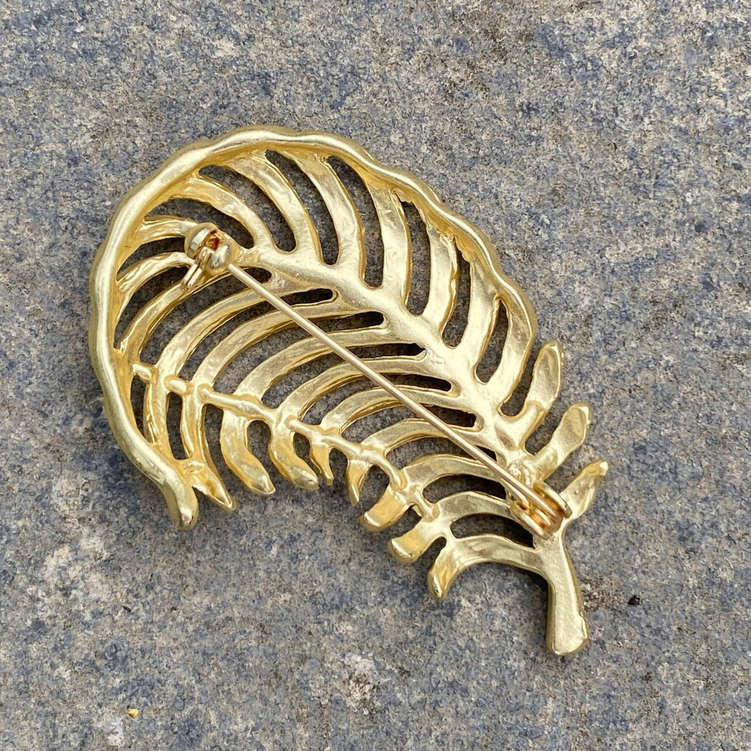 Gold fern brooch pin back view, textured detail for medieval LARP attire.